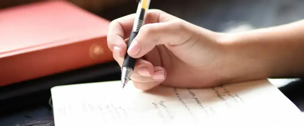 Person writing in a notebook, representing the potential to use writing skills for creating Kindle books.