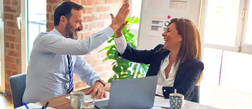 Man and Woman Giving High Five - Representing Affiliate Sales Triumph