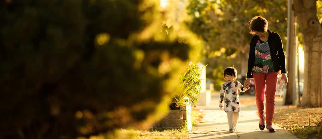 Mum walking with her son along a path, symbolizing the importance of regular movement breaks during work.