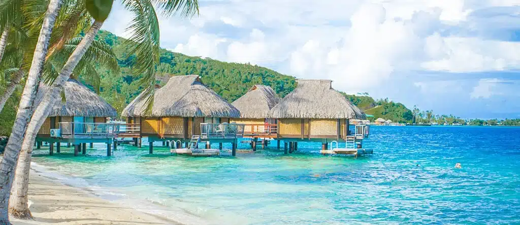 A scenic view of overwater huts at Bora Bora with turquoise water and a clear sky, symbolizing the freedom of freelancing.