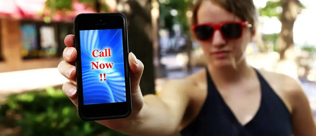 Woman holding a mobile phone with "CALL NOW" on the screen, symbolizing an effective call-to-action for readers to take immediate action.