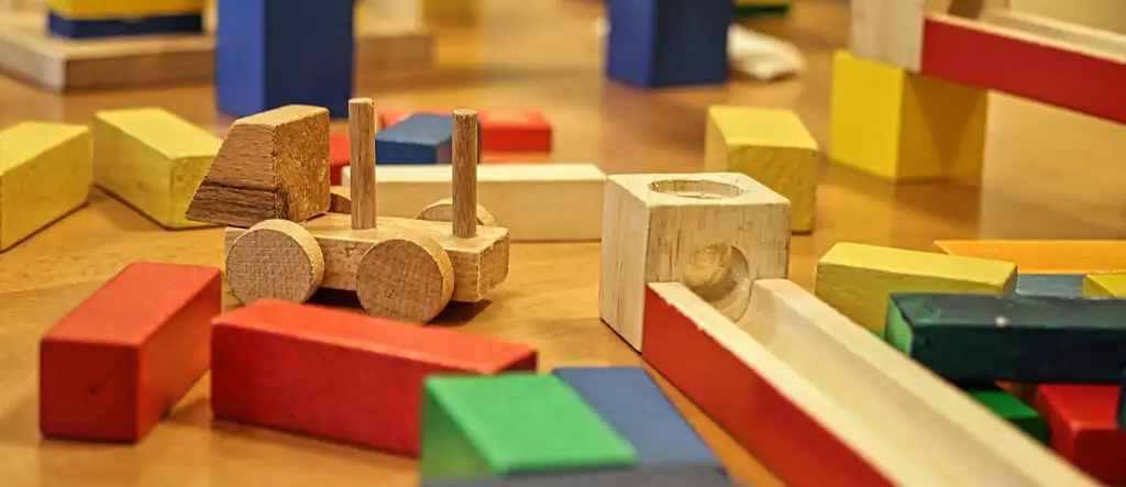 Colorful wooden building blocks arranged in a stack, representing educational toys that encourage creativity and learning.