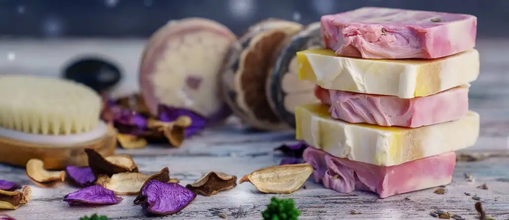 A variety of organic soaps displayed on a wooden tray, highlighting eco-friendly, natural skincare products within the health and wellness niche.