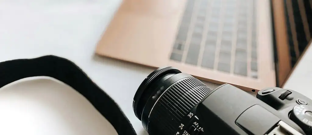 A sleek laptop with a camera beside it, symbolizing tools for aspiring online marketers to create content and manage their digital business.