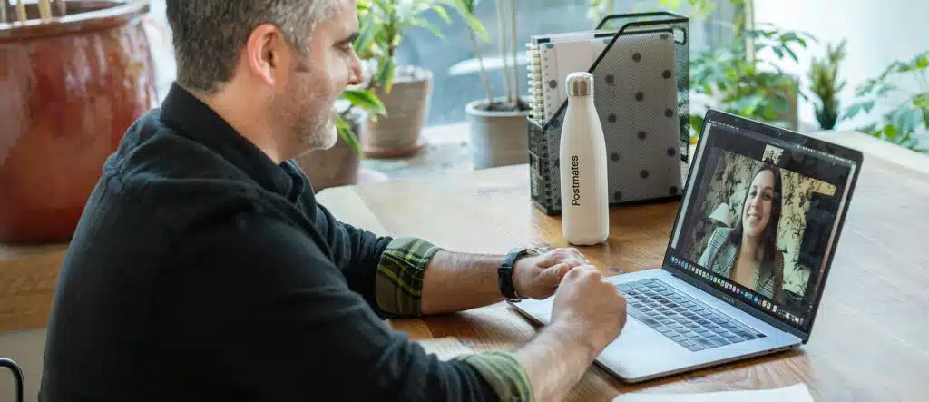 A man talking to someone on his laptop, symbolizing communication and collaboration in online business success.